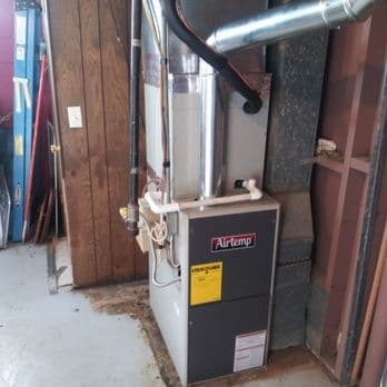 A mechanical heating or cooling unit with ductwork and piping installed in an indoor space, featuring a visible Airtemp brand label.